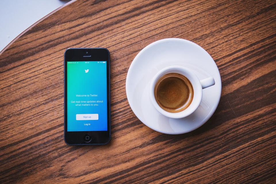 Phone and coffee on a wooden table