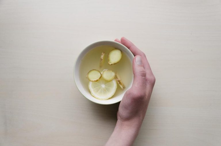 Hand holding a cup of lemon tea